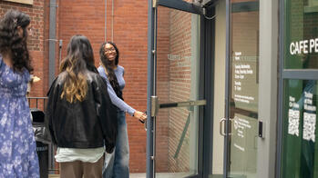 three international students walking through a door 