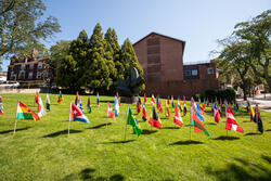 flags from several countries standing on the ground on RISD beach